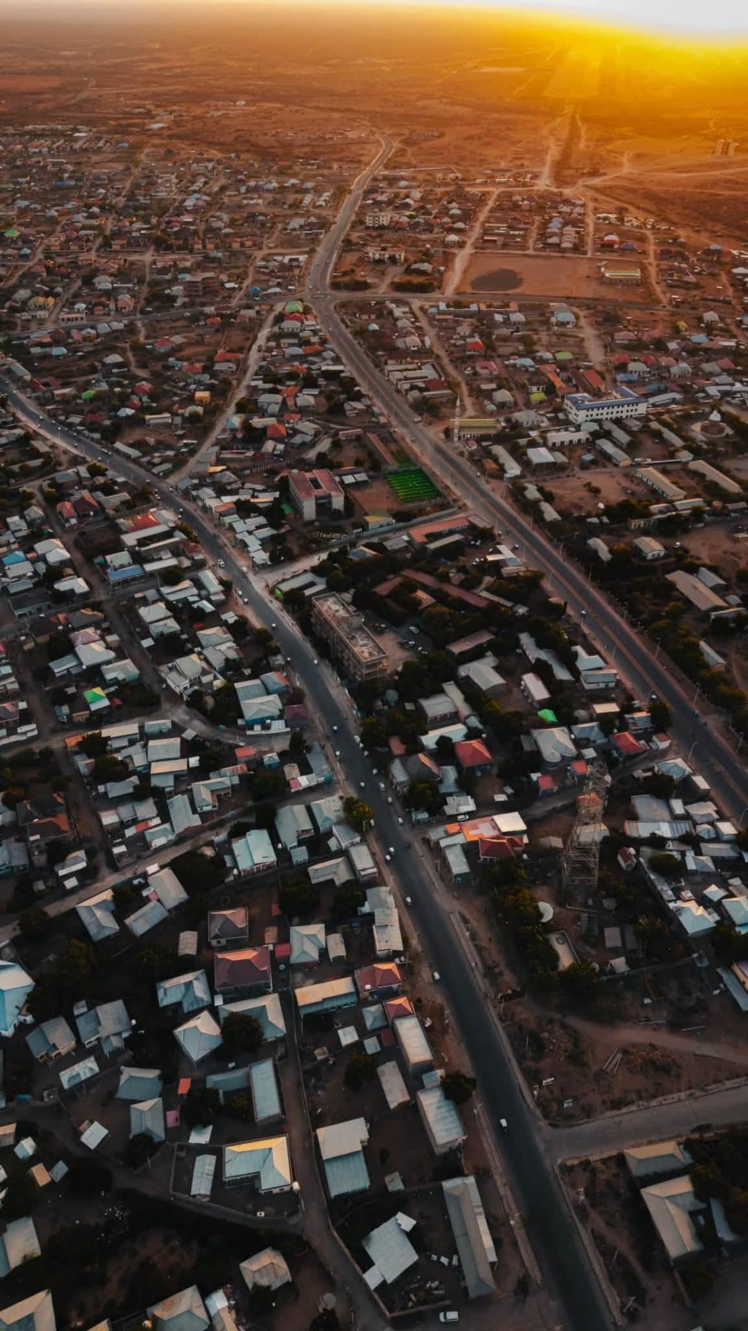 Aerial view over a town and hills at sunset