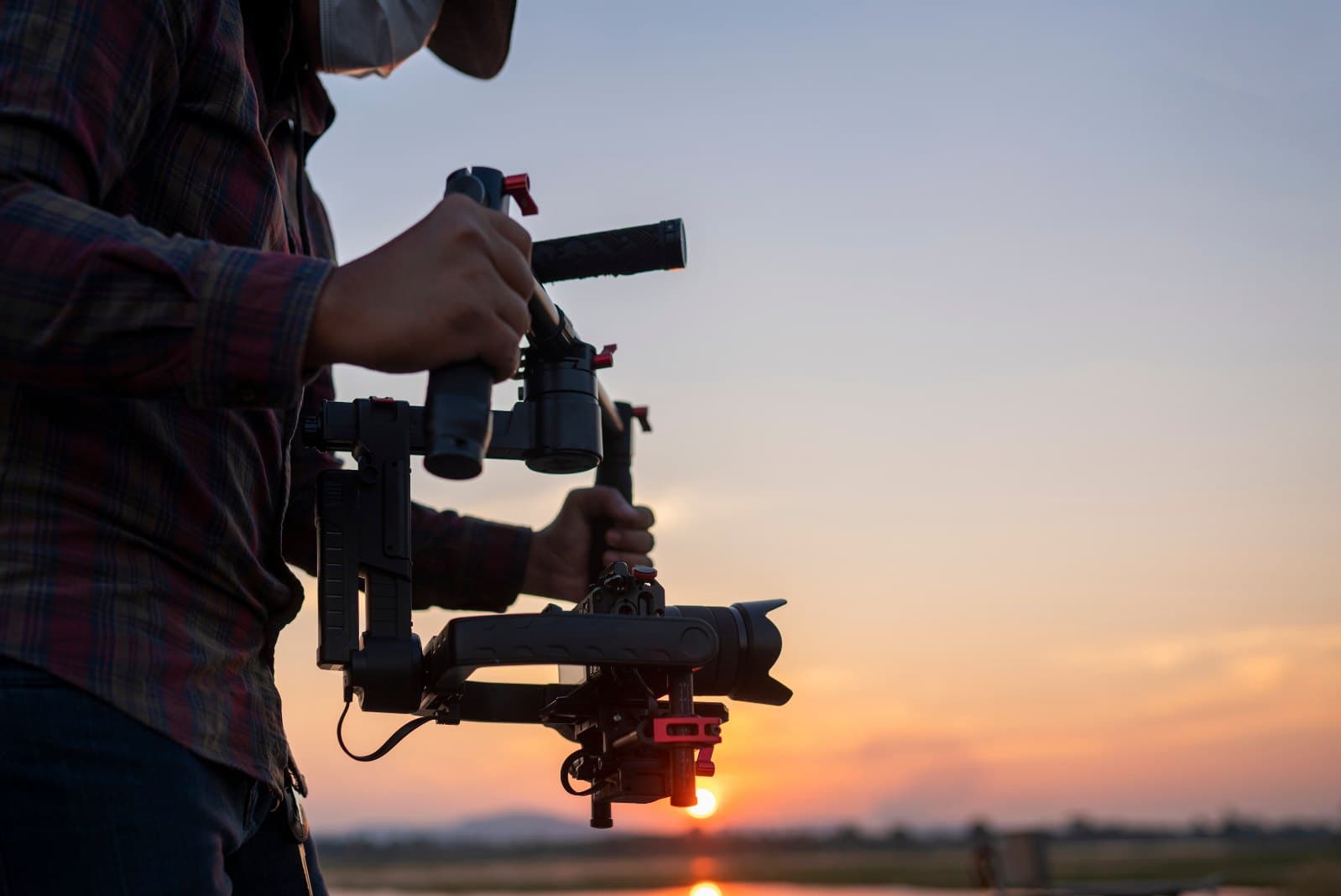 Camera operator with a gimbal at sunset