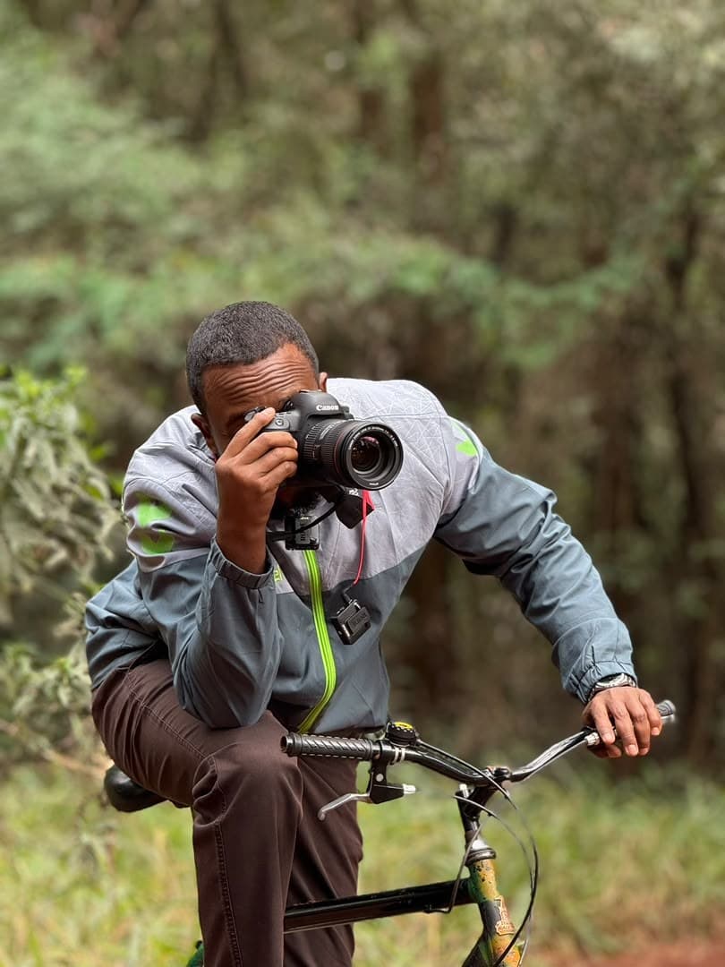 Kamil Ahmed photographing in a forest with a Canon camera